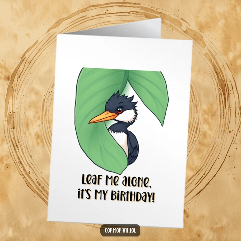 Funny Free Printable Birthday Card: Cormorant peeking from behind a giant wet leaf, looking mischievous. Perfect for bird lovers.