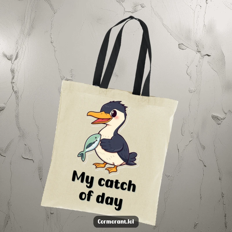 Funny cormorant tote bag featuring a smiling bird proudly holding a shiny fish in its beak, perfect for carrying gear.