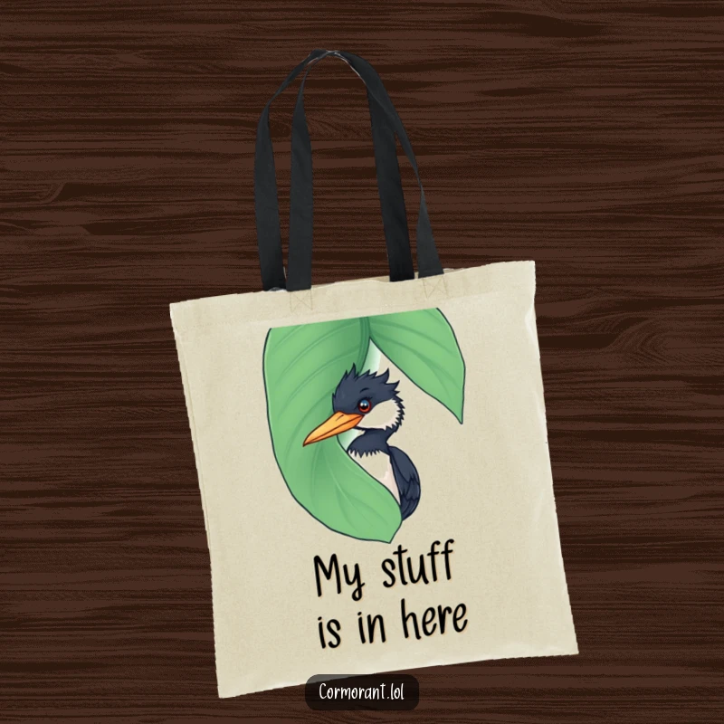 Funny Cormorant Tote Bag: A cheeky cormorant peeking from behind a wet leaf, showcasing a funny and secretive bird demeanor.